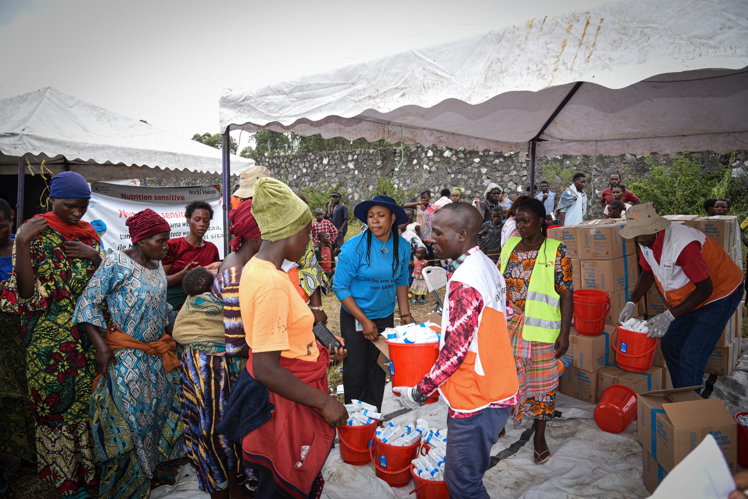 Women lining up to receive high-energy biscuits from World Vision staff at a displacement camp