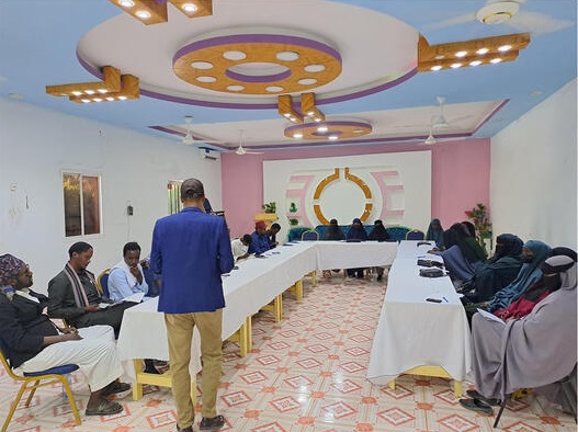 Workshop with women and key religious leaders in a conference room.