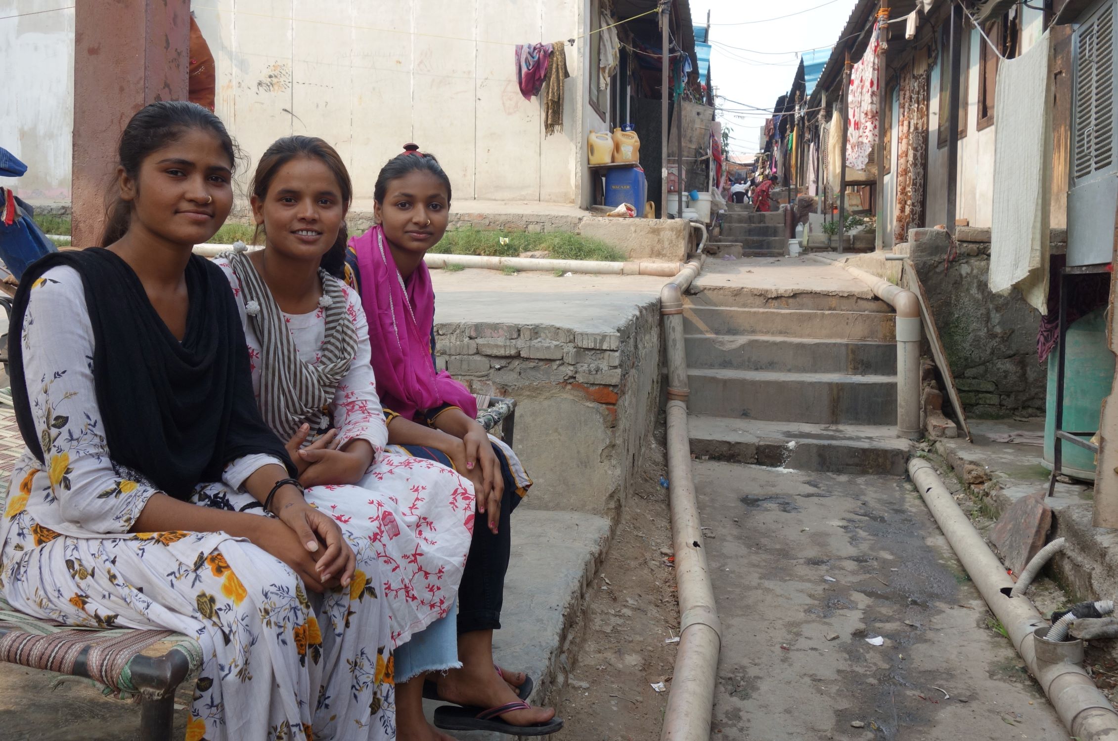 Three rag pickers sitting in their community in India