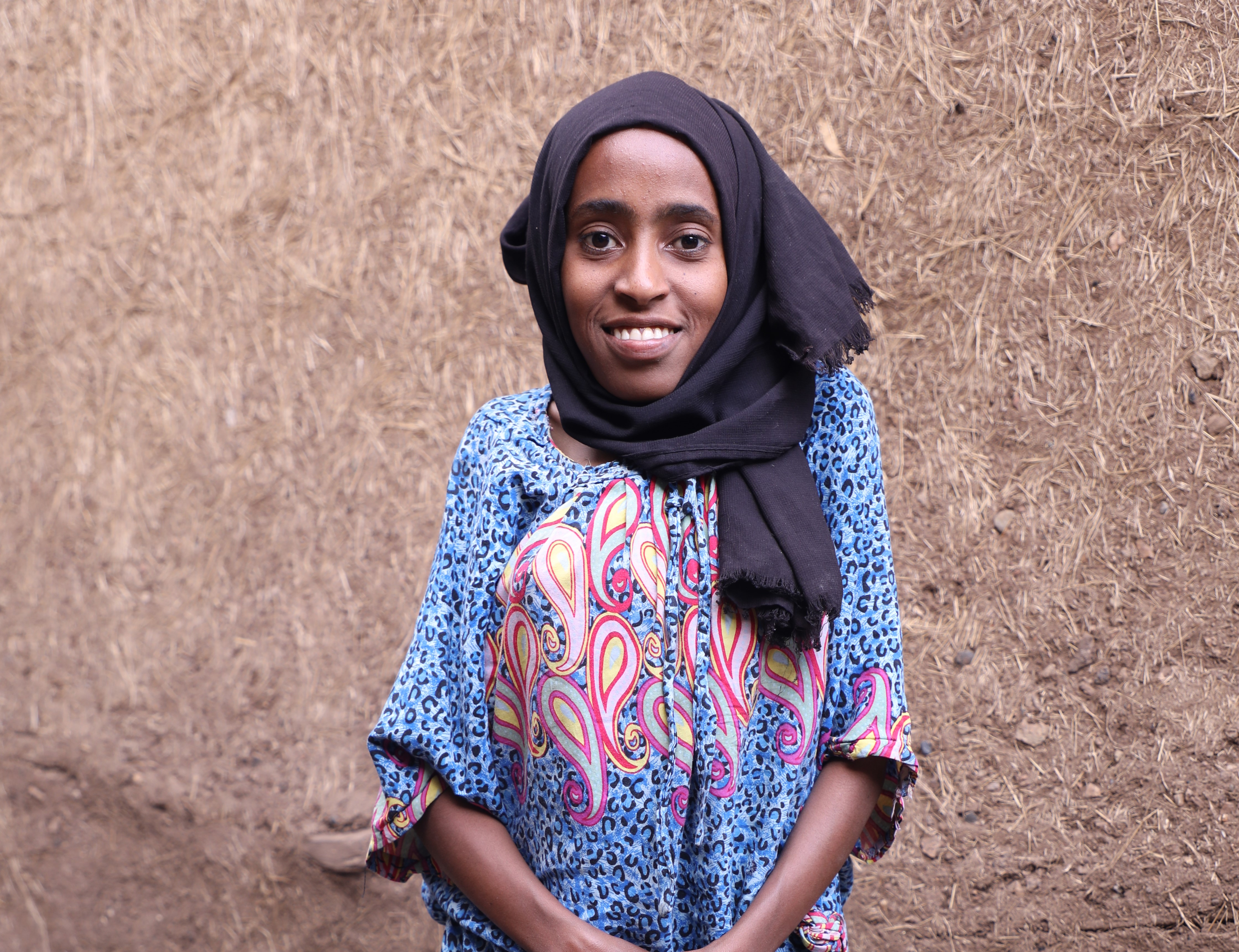 Merem, 16, stand in front of her home