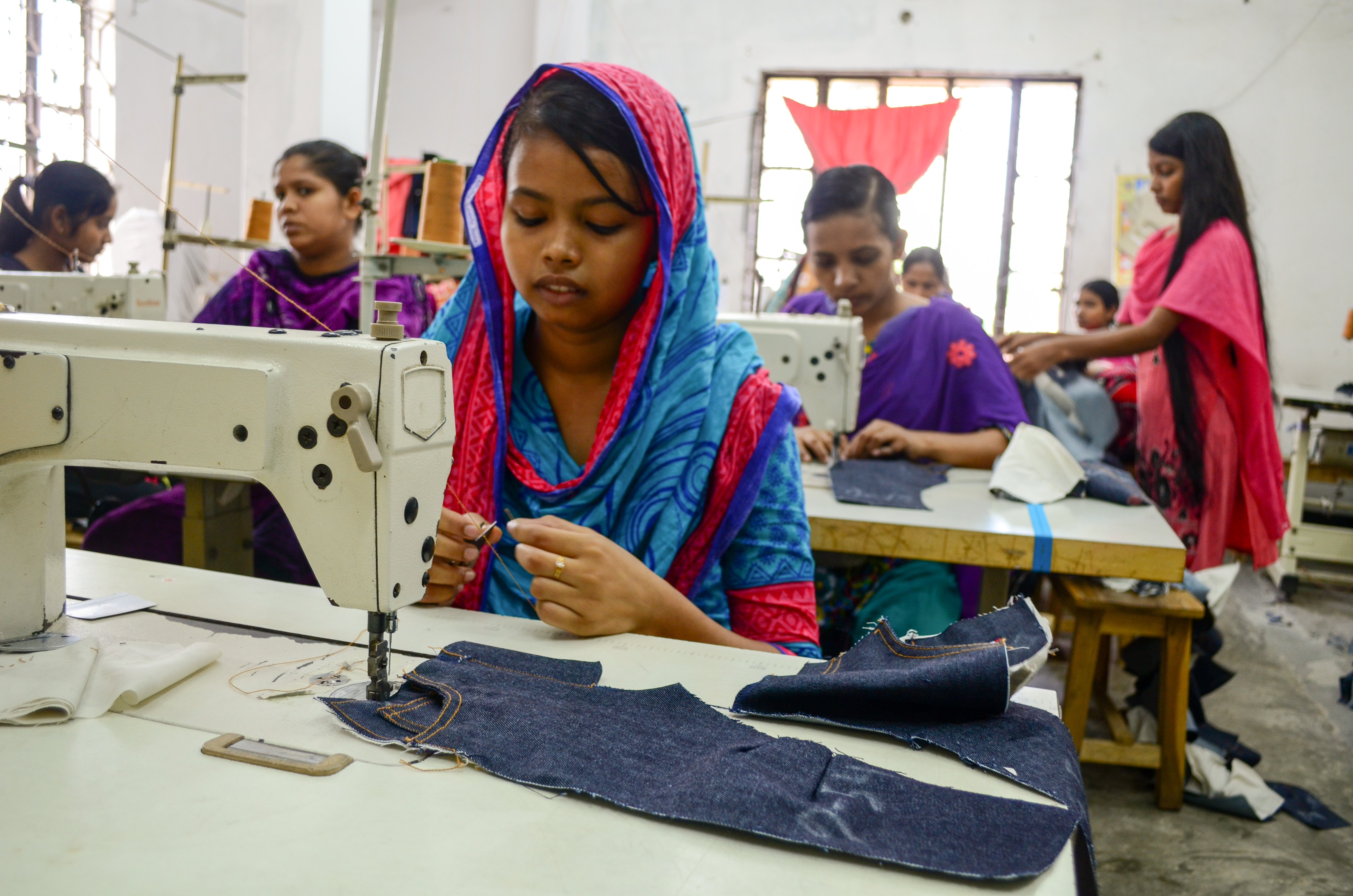 Bithi, at the garment factory, piecing together designer jeans.