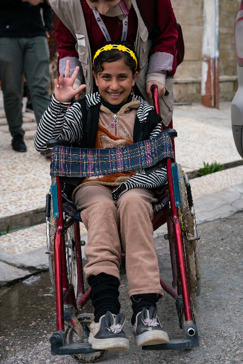 Raja smiling in her wheelchair