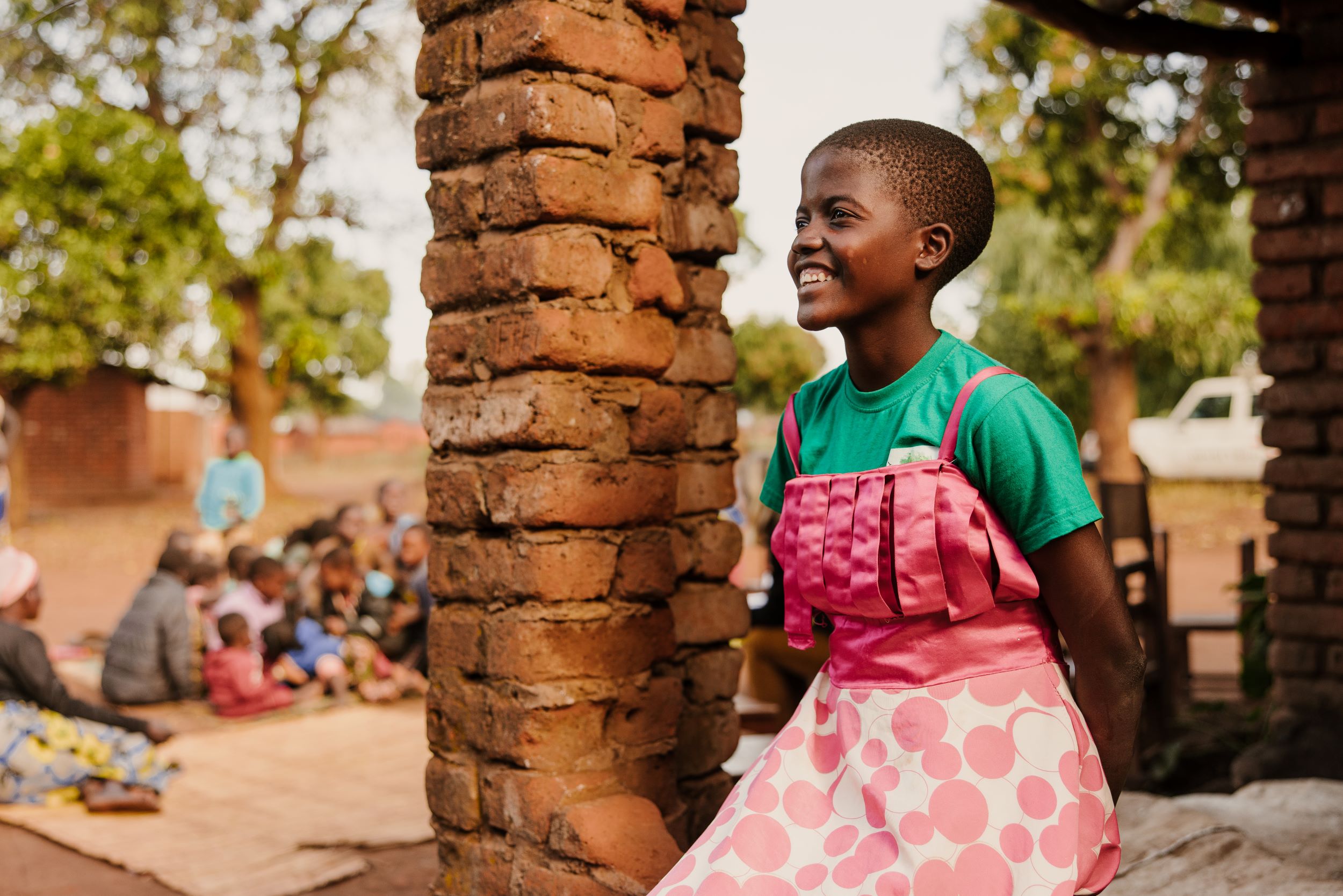Young Malawi girl smiling in pink dress