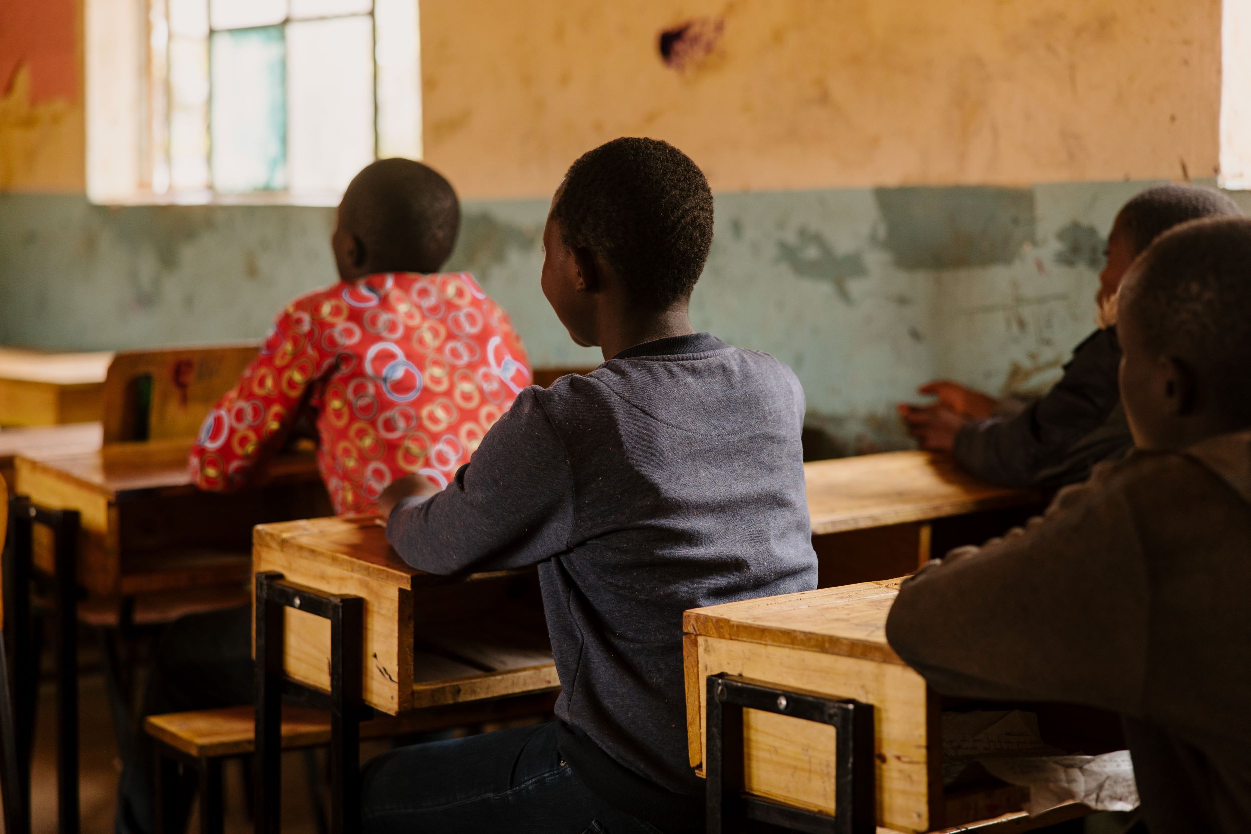 Kenyan girl sitting at desk in classroom