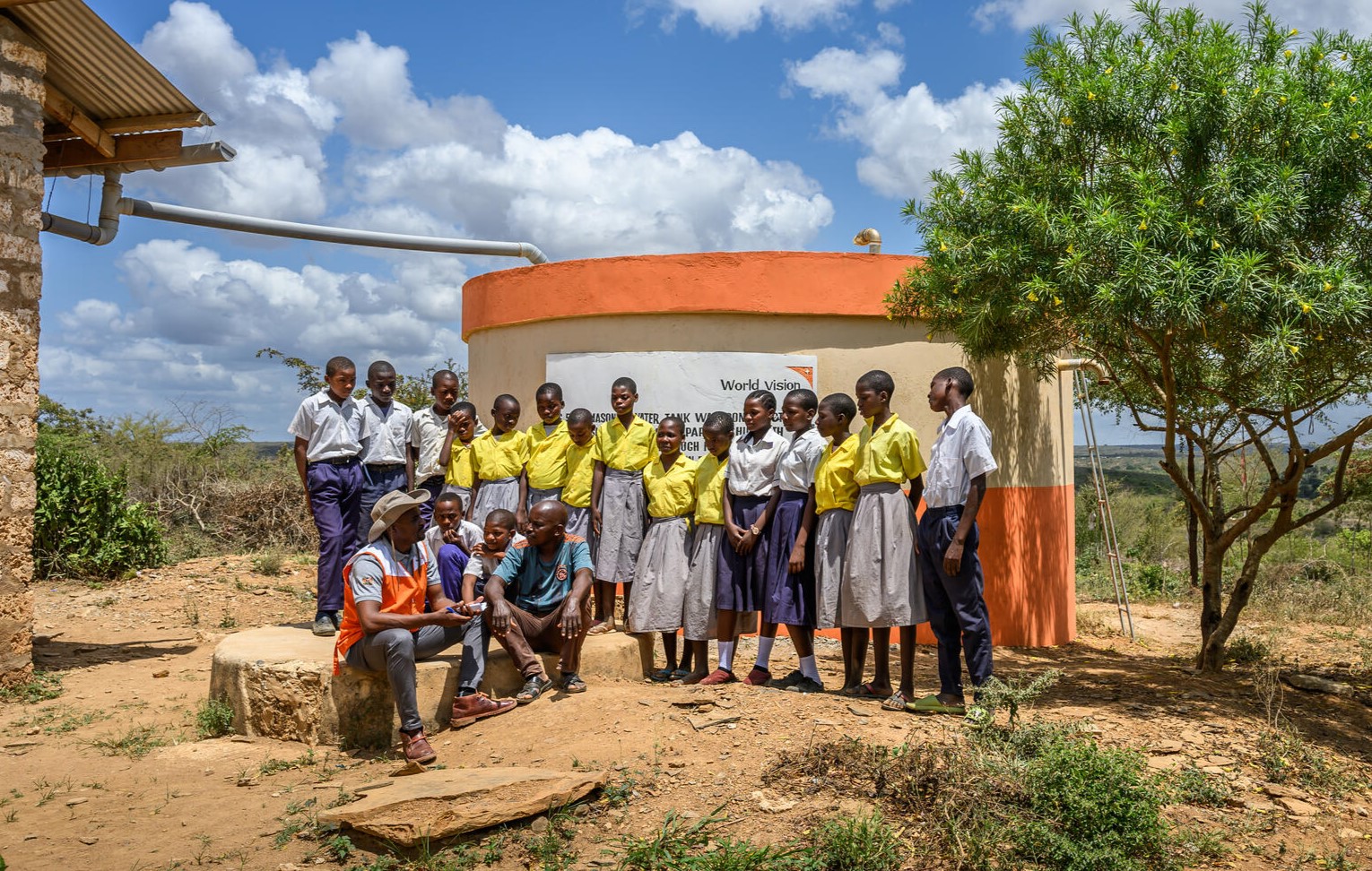 Children stand in front of the school's new rainwater tank