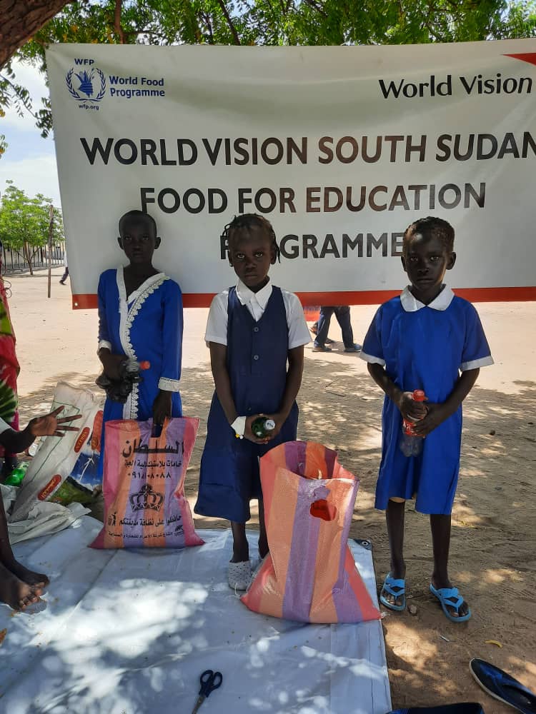 Three children with supplies in South Sudan