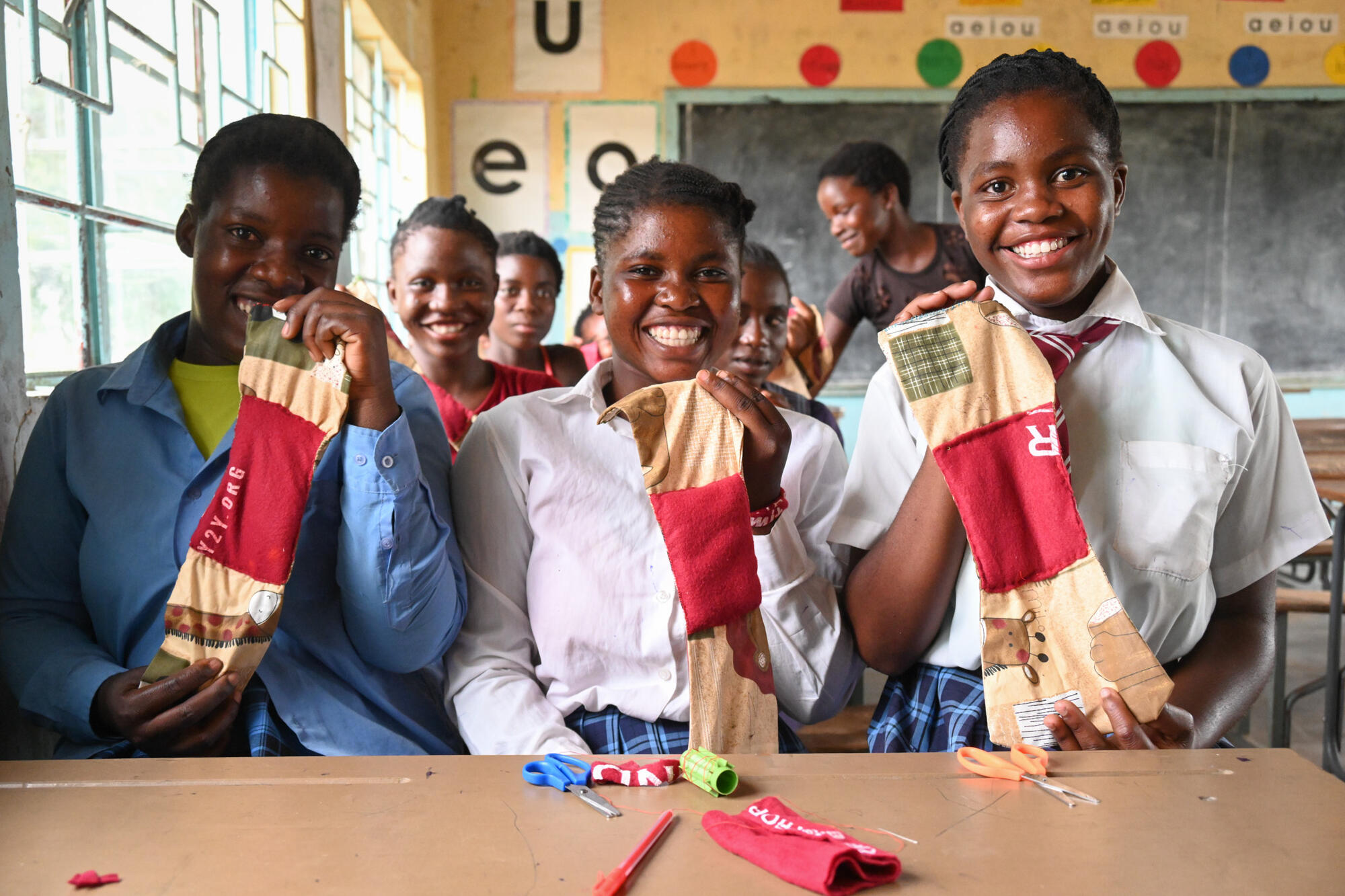 Esther (far right) and friends show the pads they've made in class in Zambia