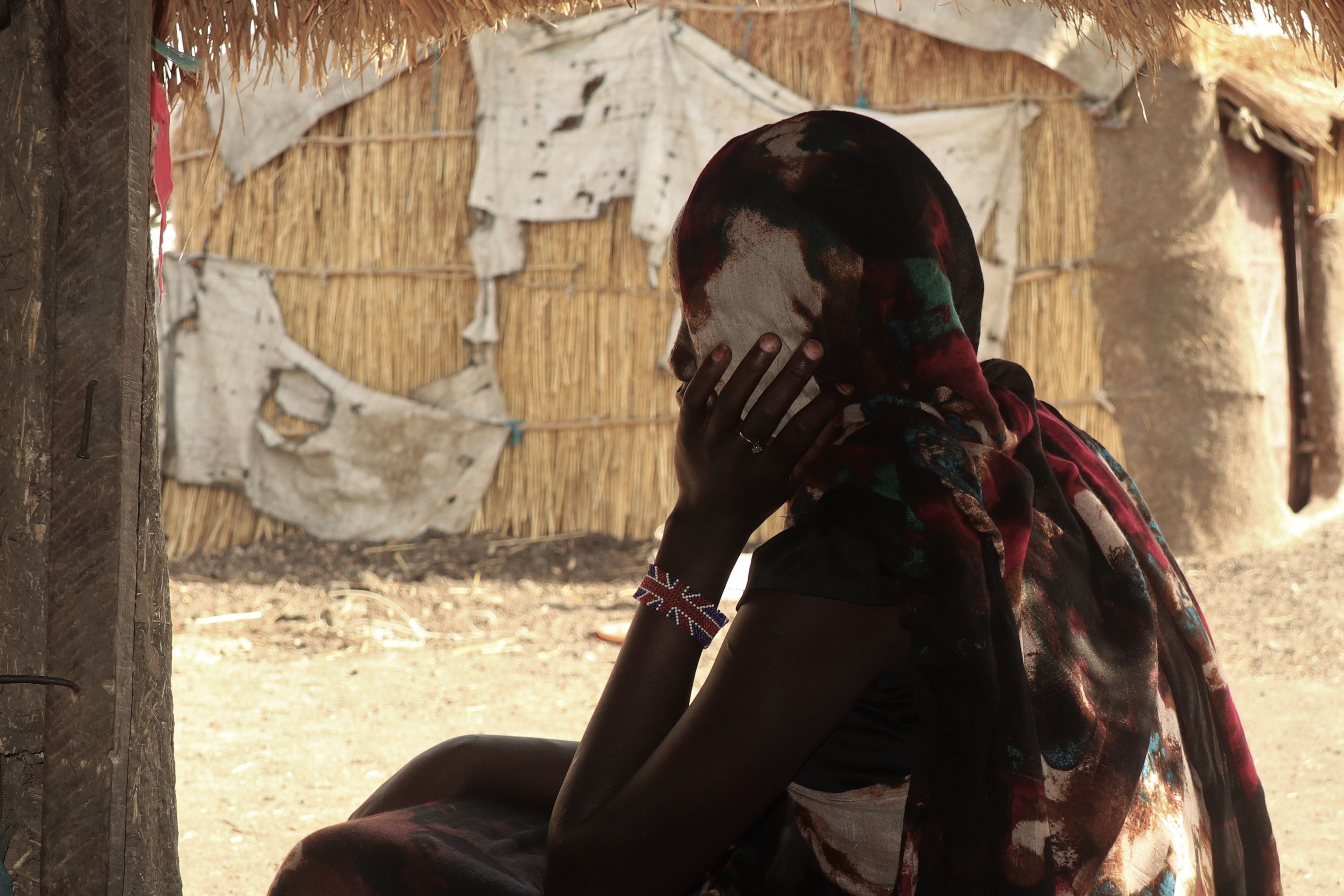 Girl in Afghanistan looks away from the camera towards flower decorations prepared for her child marriage
