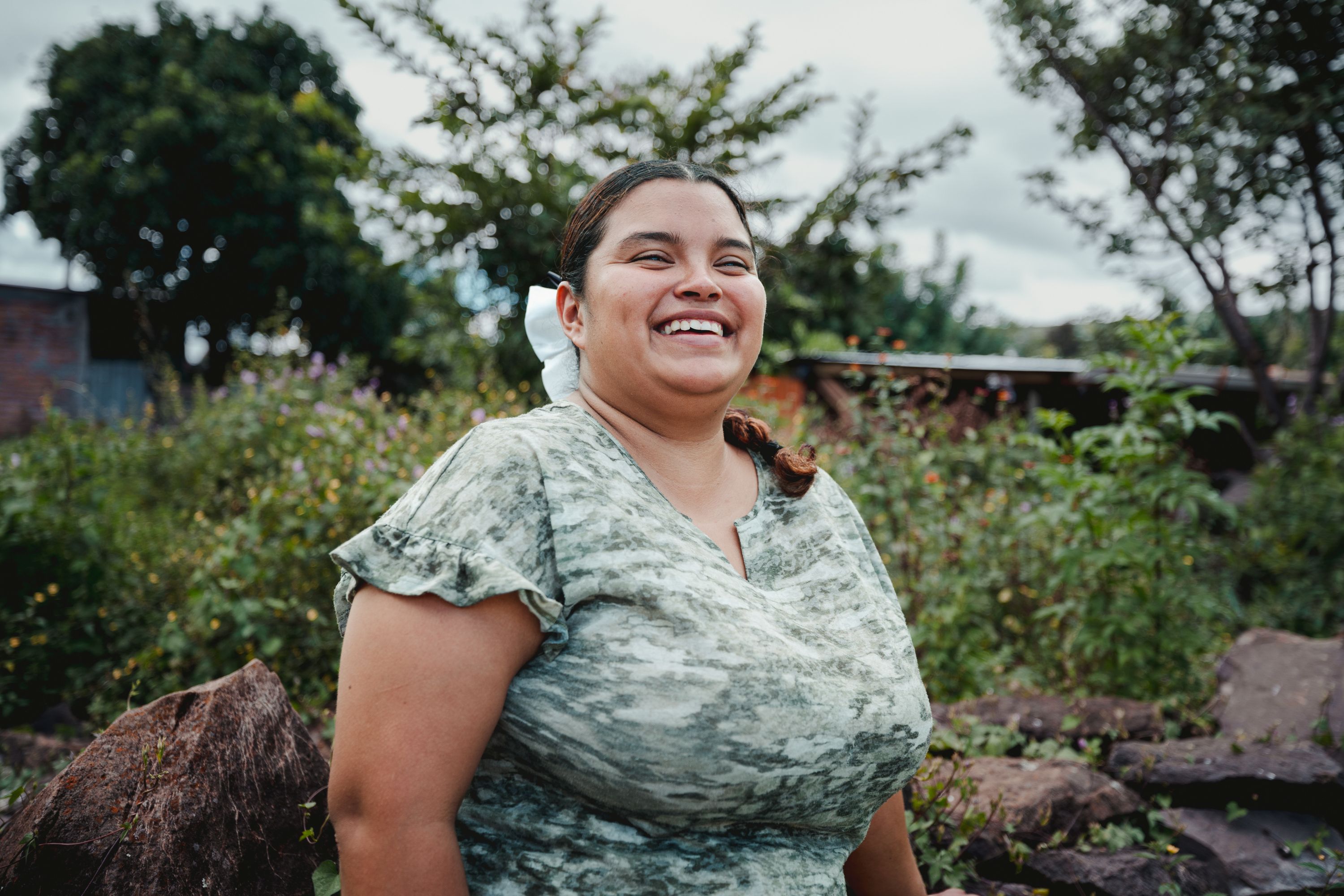 Lisbeth smiles as she poses outside in her community