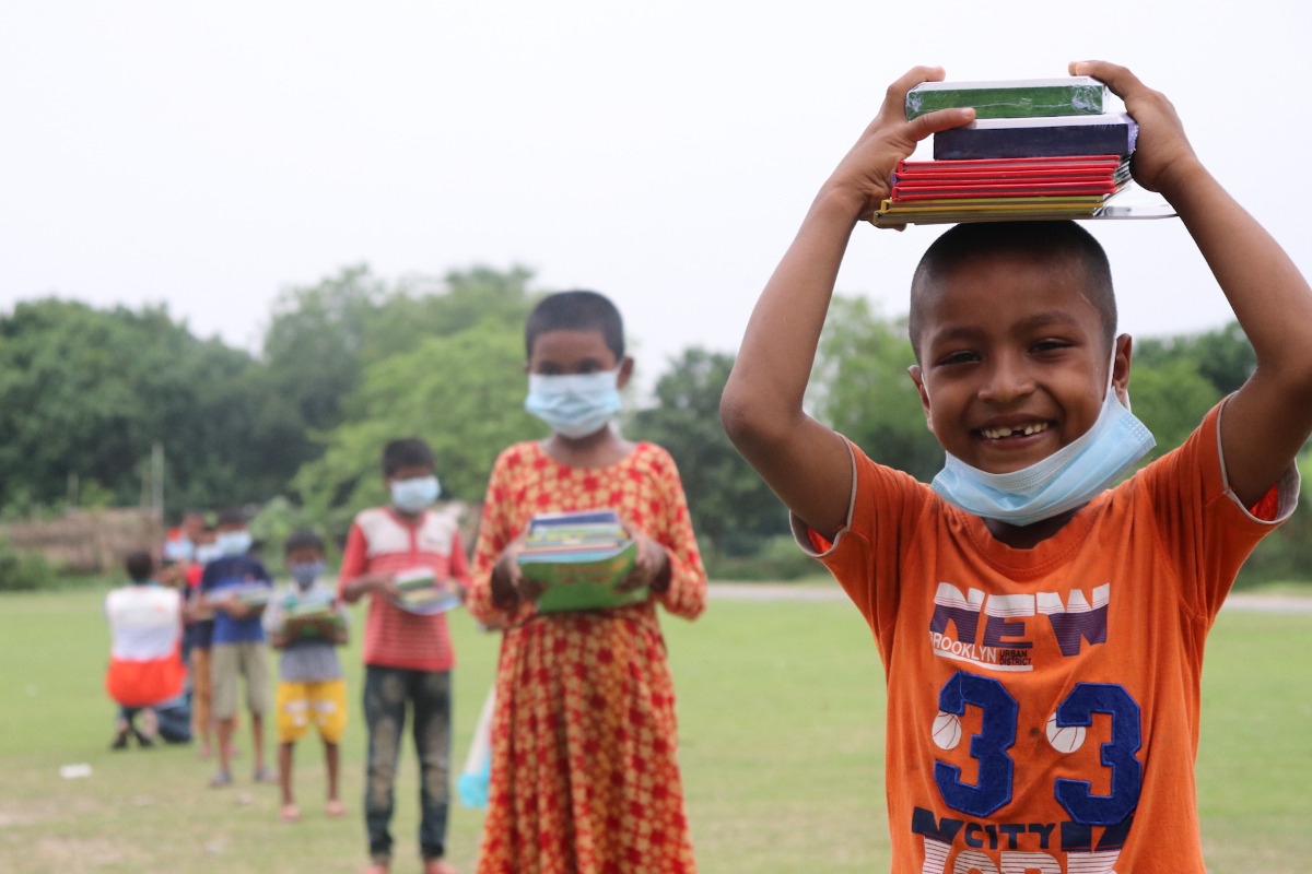 Children with masks and school books