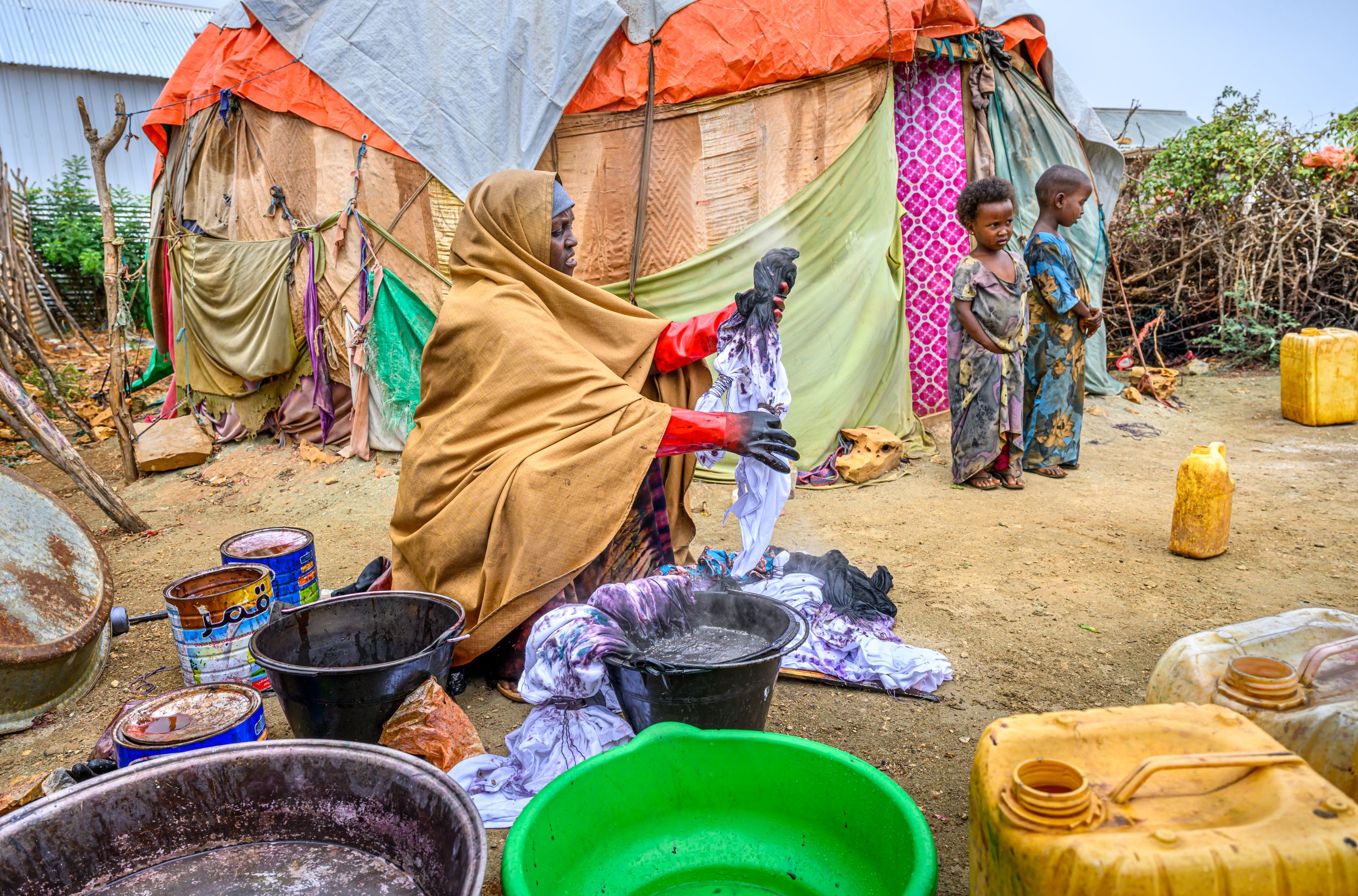 Somali woman dyeing fabric in a bucket