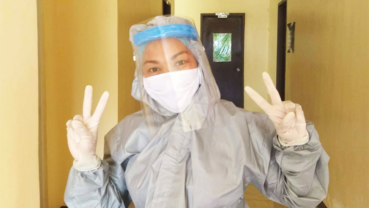 A health worker in the Philippines flashes the peace sign, wearing full protective gear to prevent the spread of COVID-19
