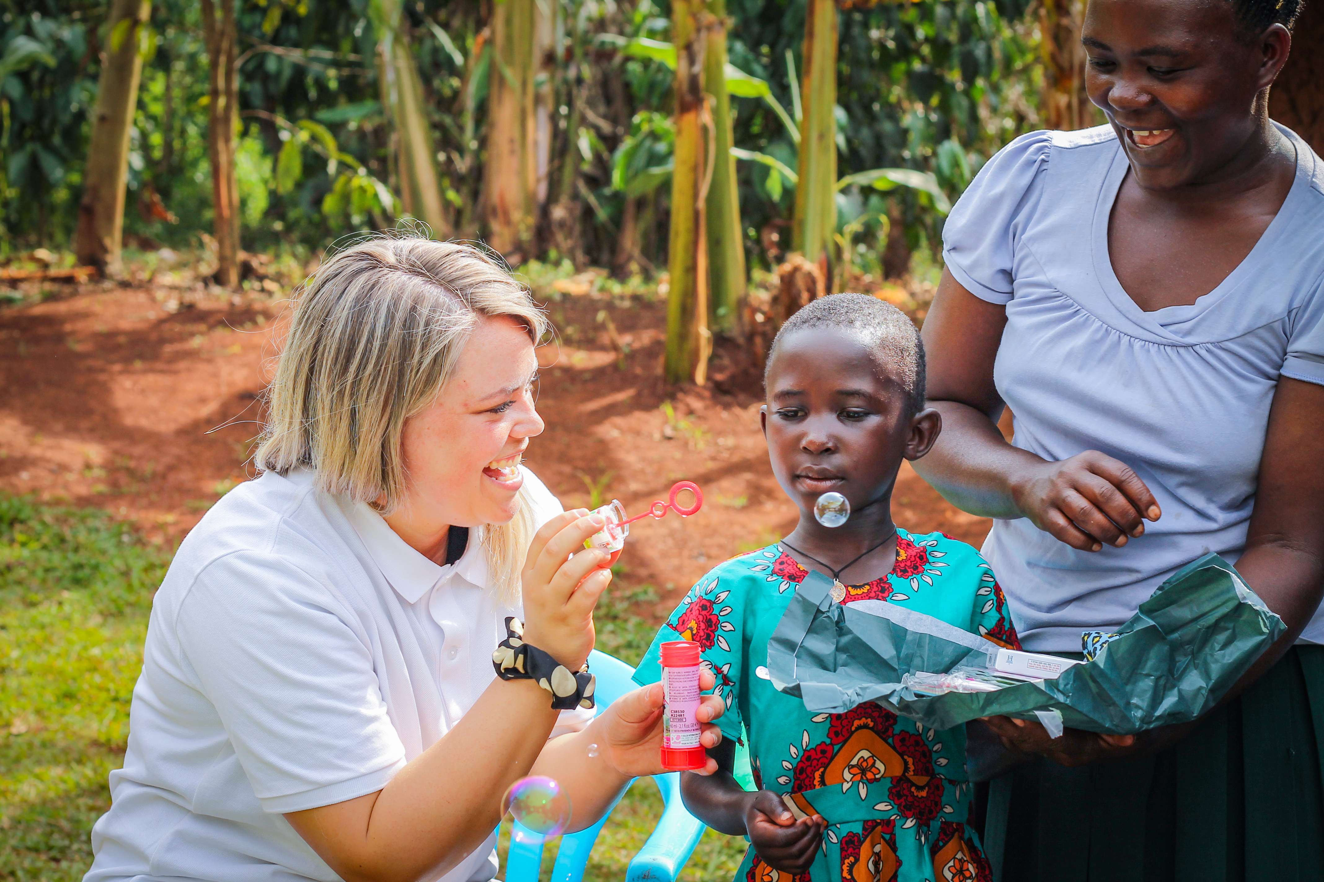 A sponsor meeting her sponsored child in Uganda. Playing with bubbles