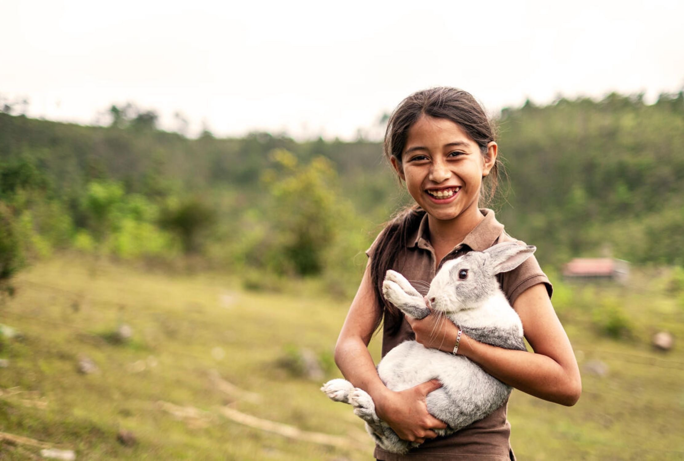 Cambodian girl holding a rabbit and smiling