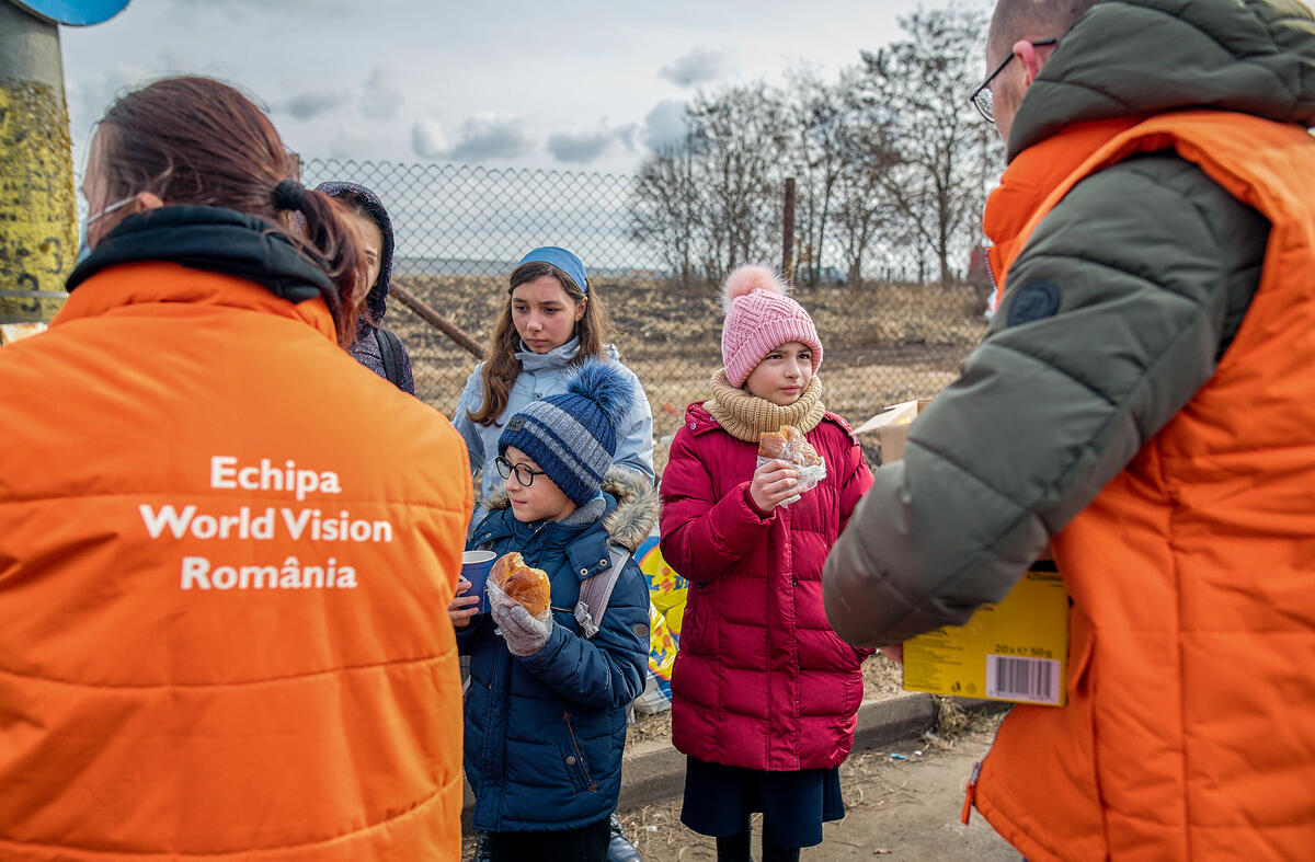 World Vision workers greet a group of children as they cross the boarder from Ukraine