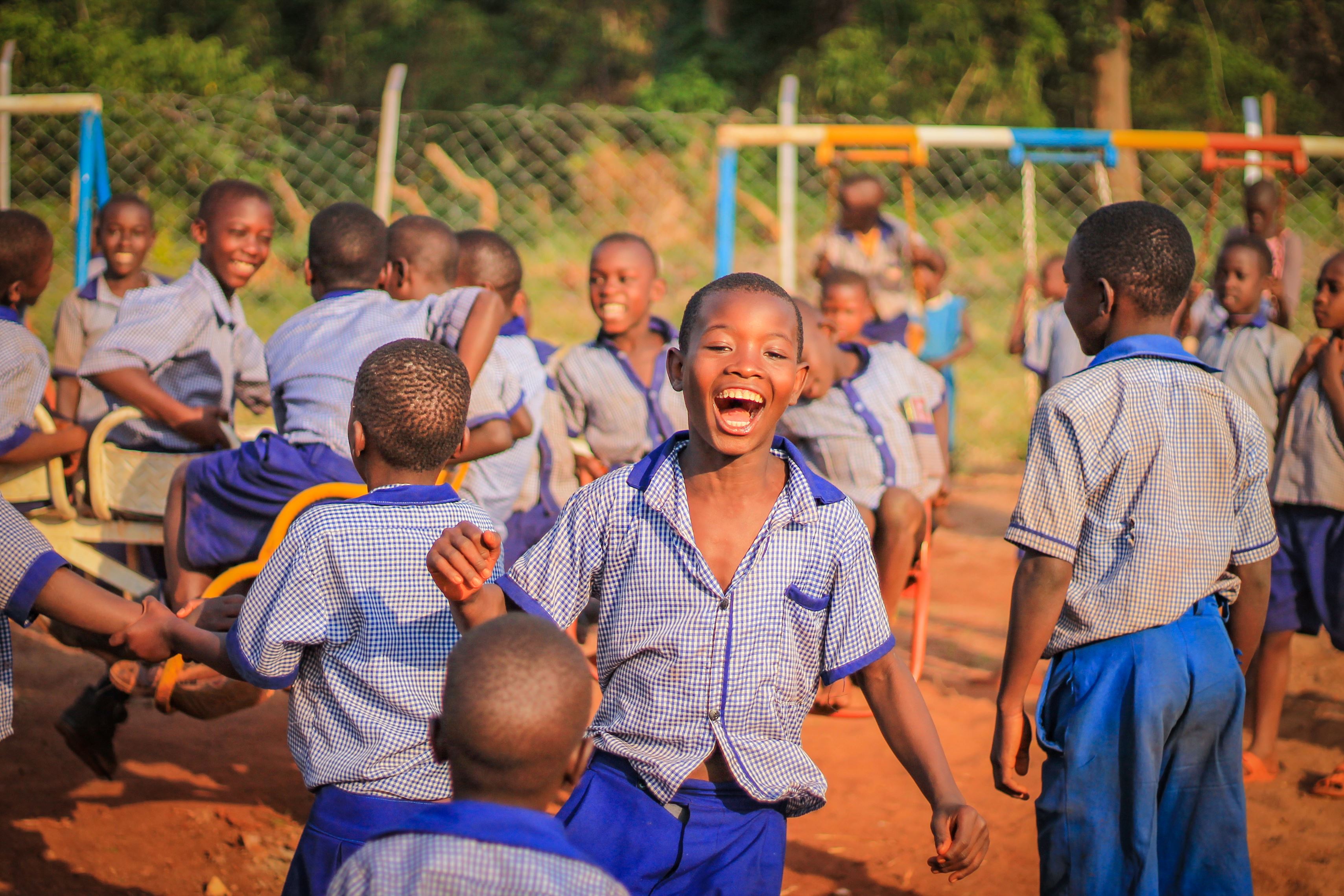 Children play in uniform, in a school playground in Uganda