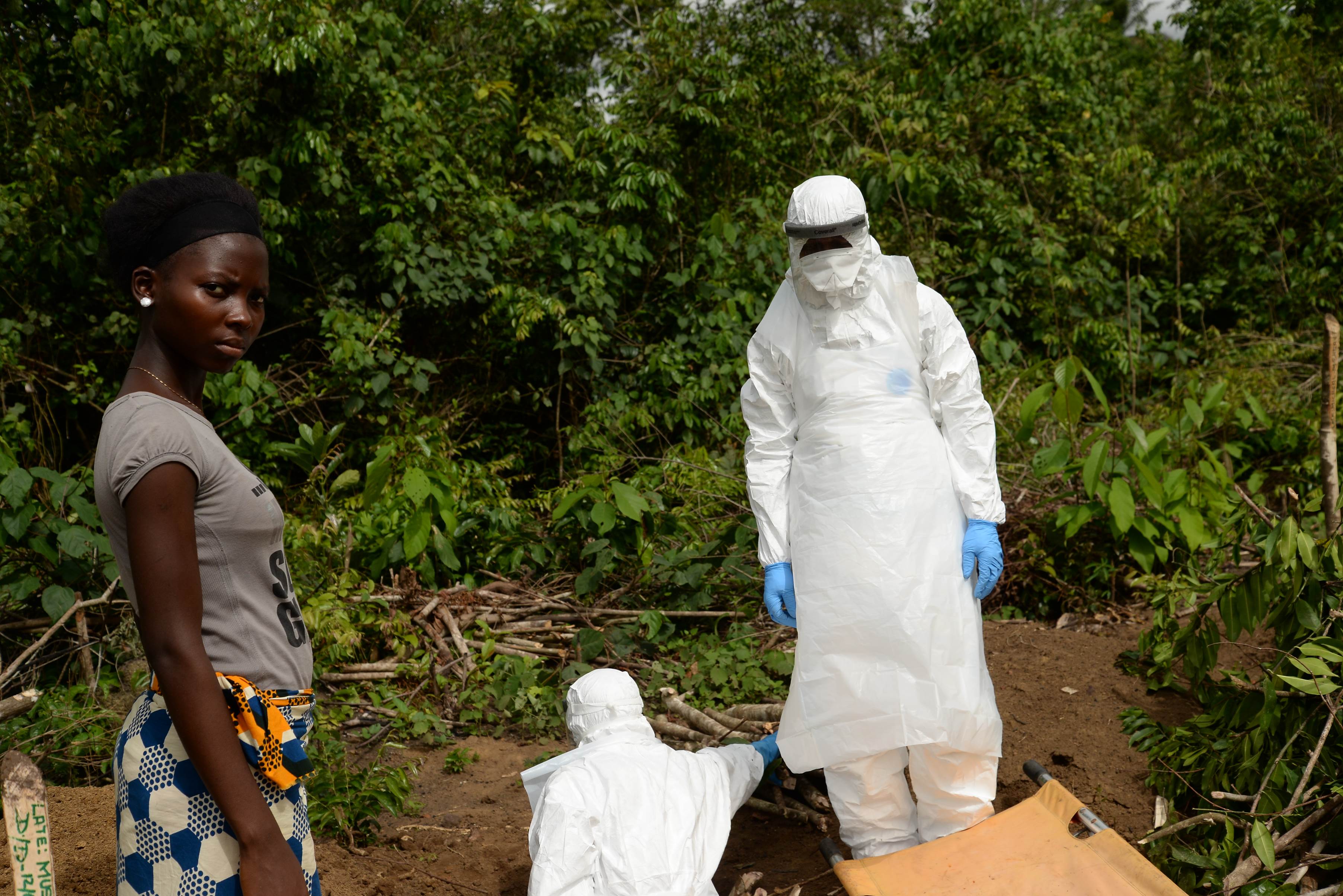Young girl stood next to person in hazmat suit