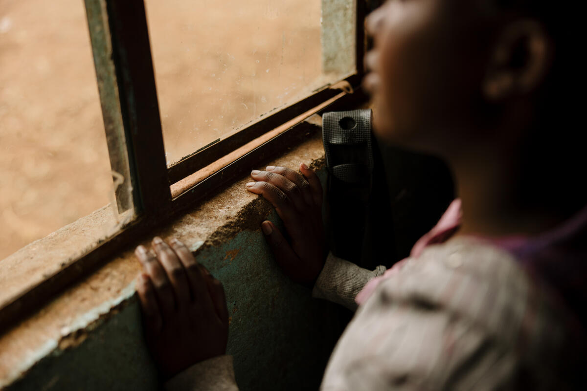 Kenyan teenager silhouette looking out window
