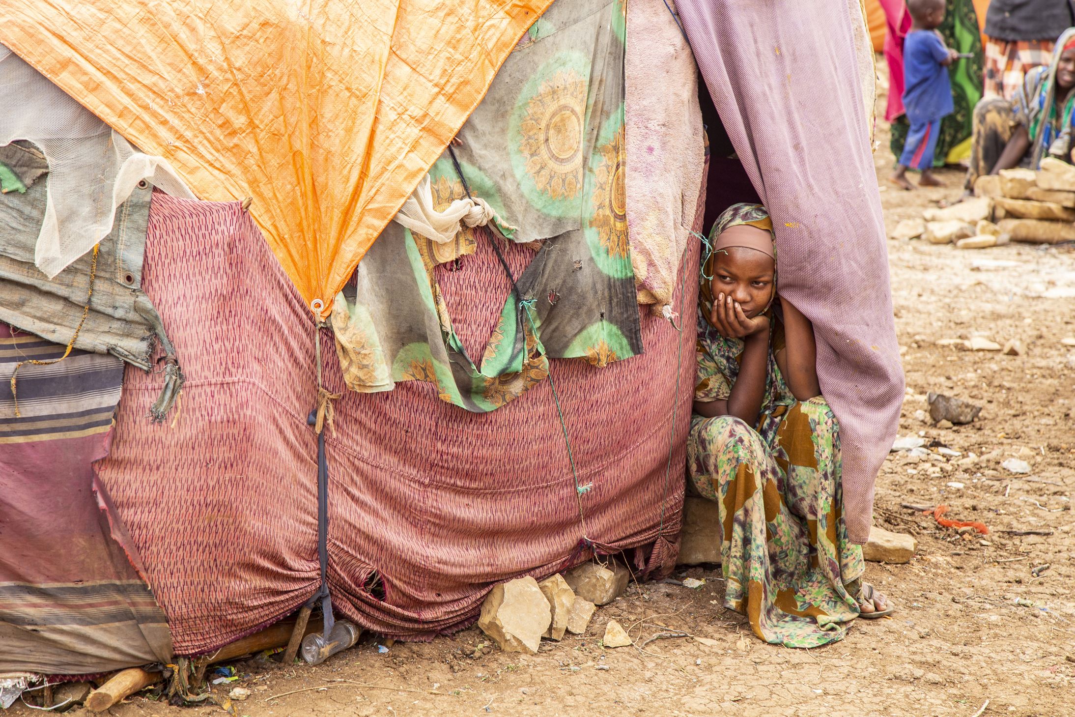 Displaced Somalian girl in the Baidoa camp looks out of a makeshift shelter her family lives in.