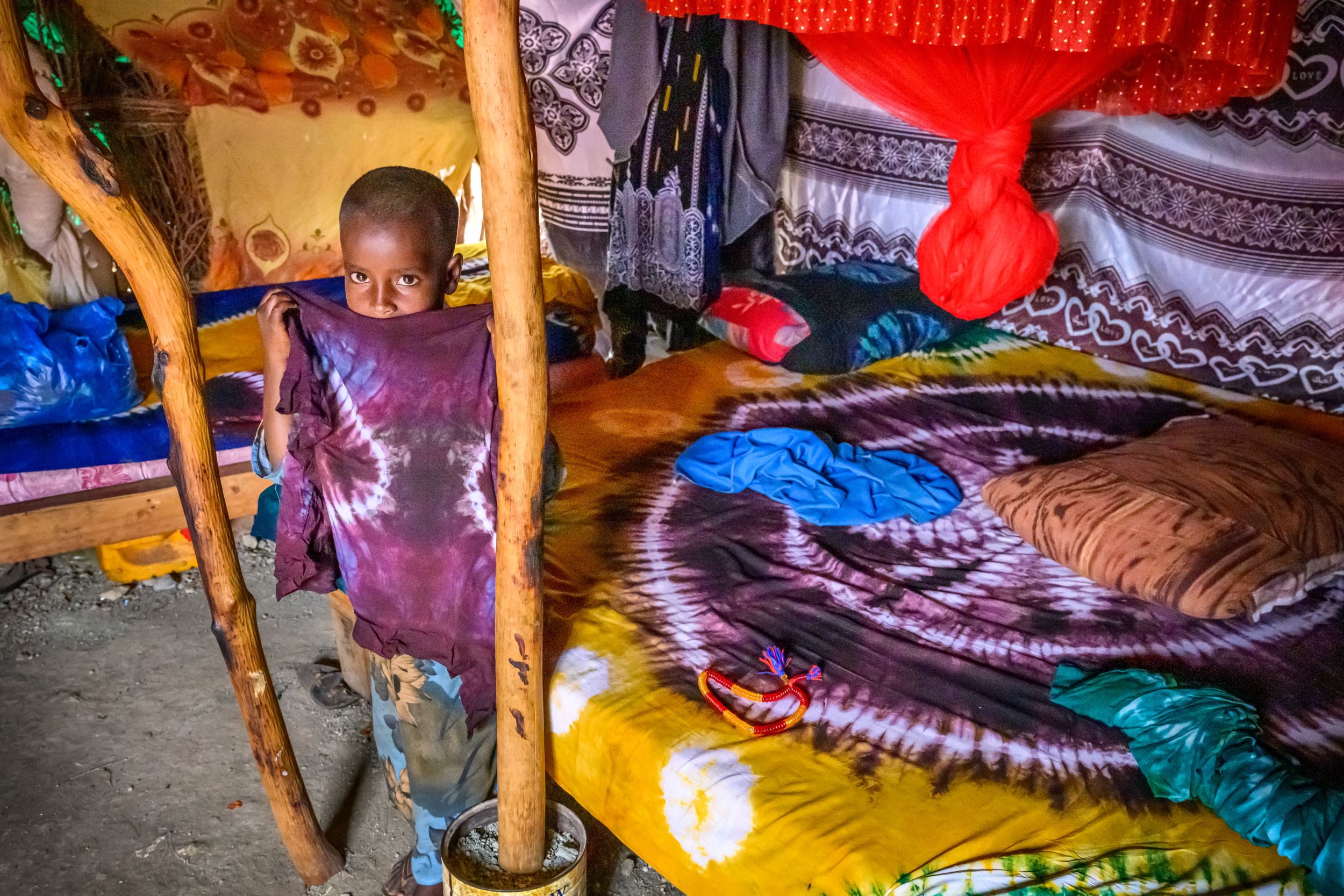 Somali girl poses with colourful fabric in the family home 