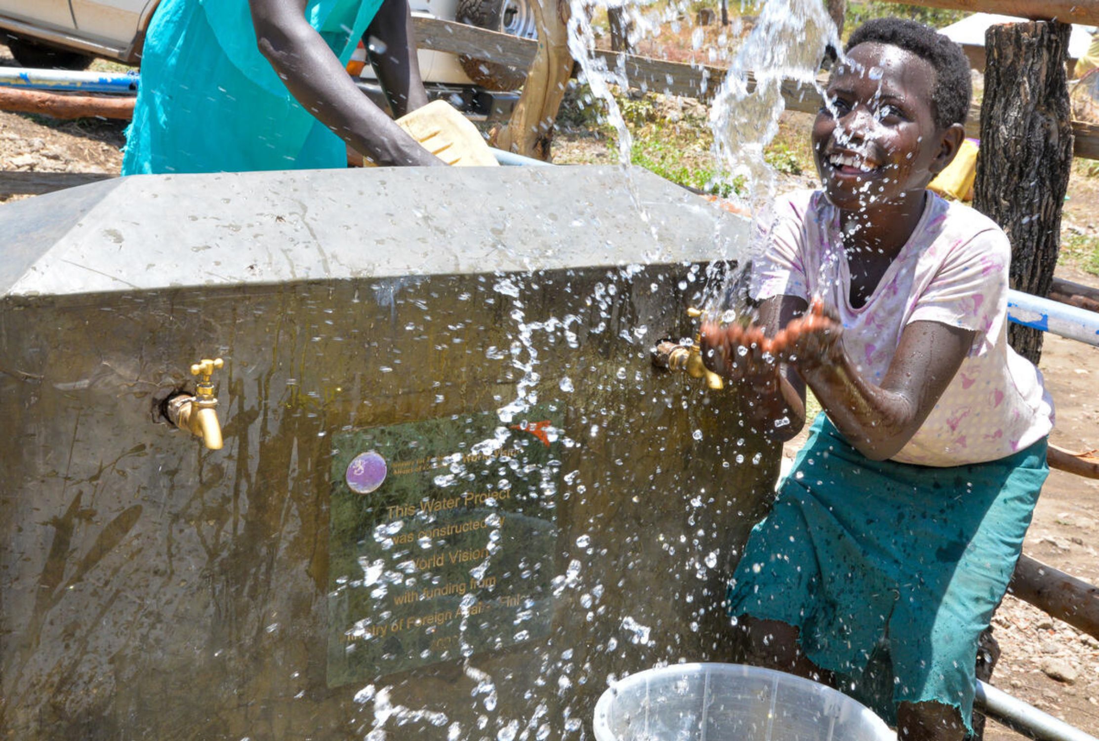 Girl from Uganda enjoying playing with water from water tap