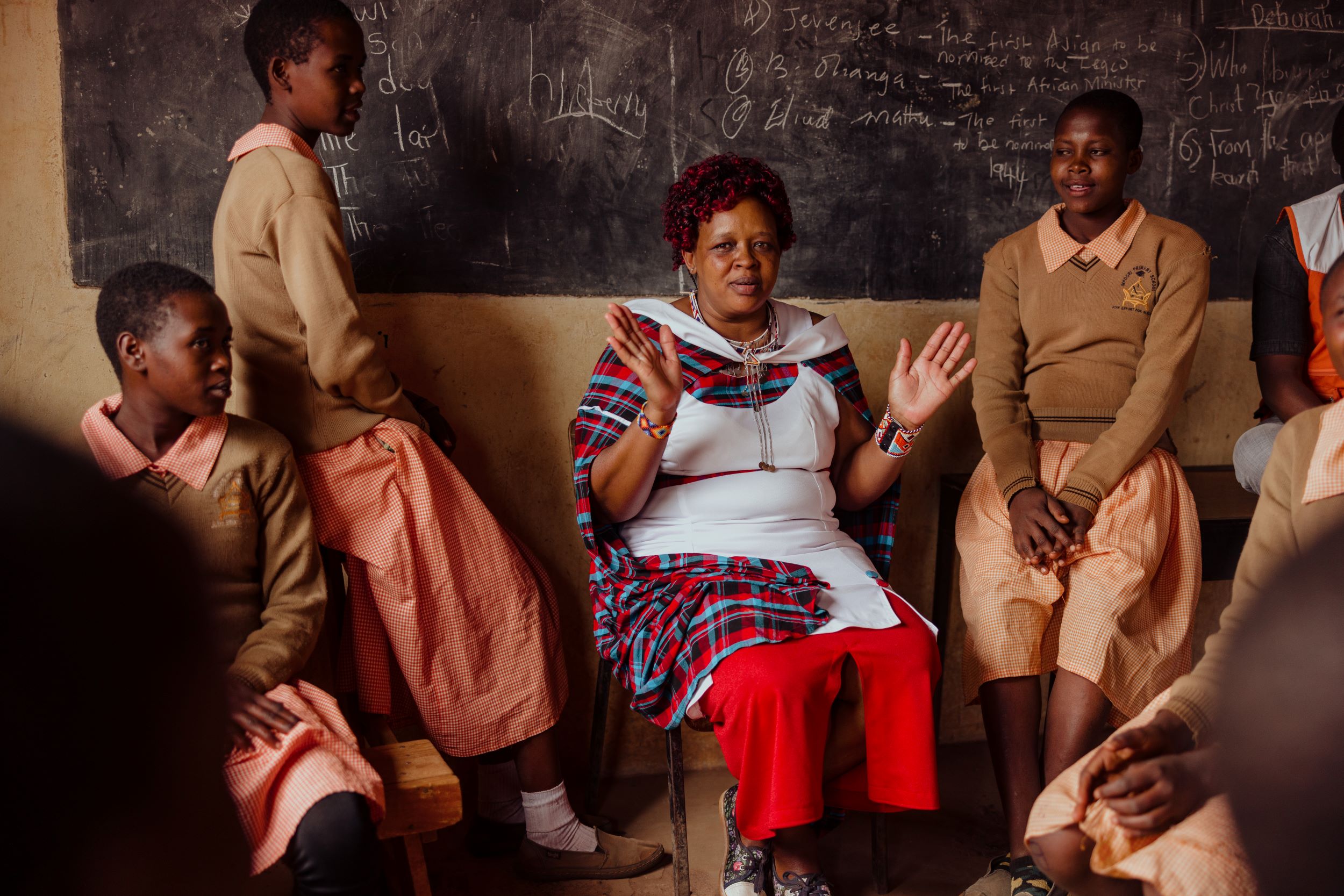 Kenyan woman teaching girls about FGM in classroom setting