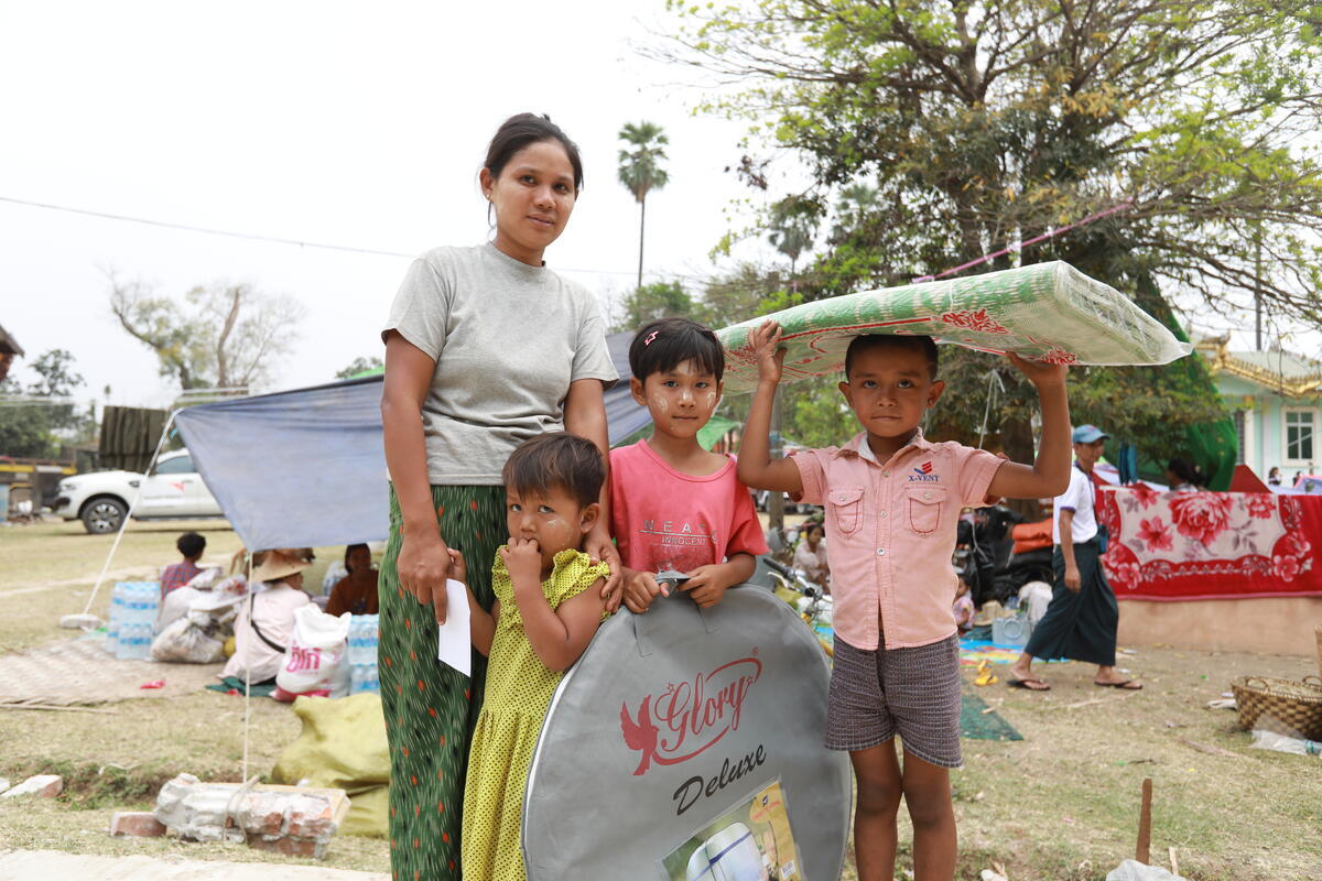 A mother and her three children hold their mosquito nets