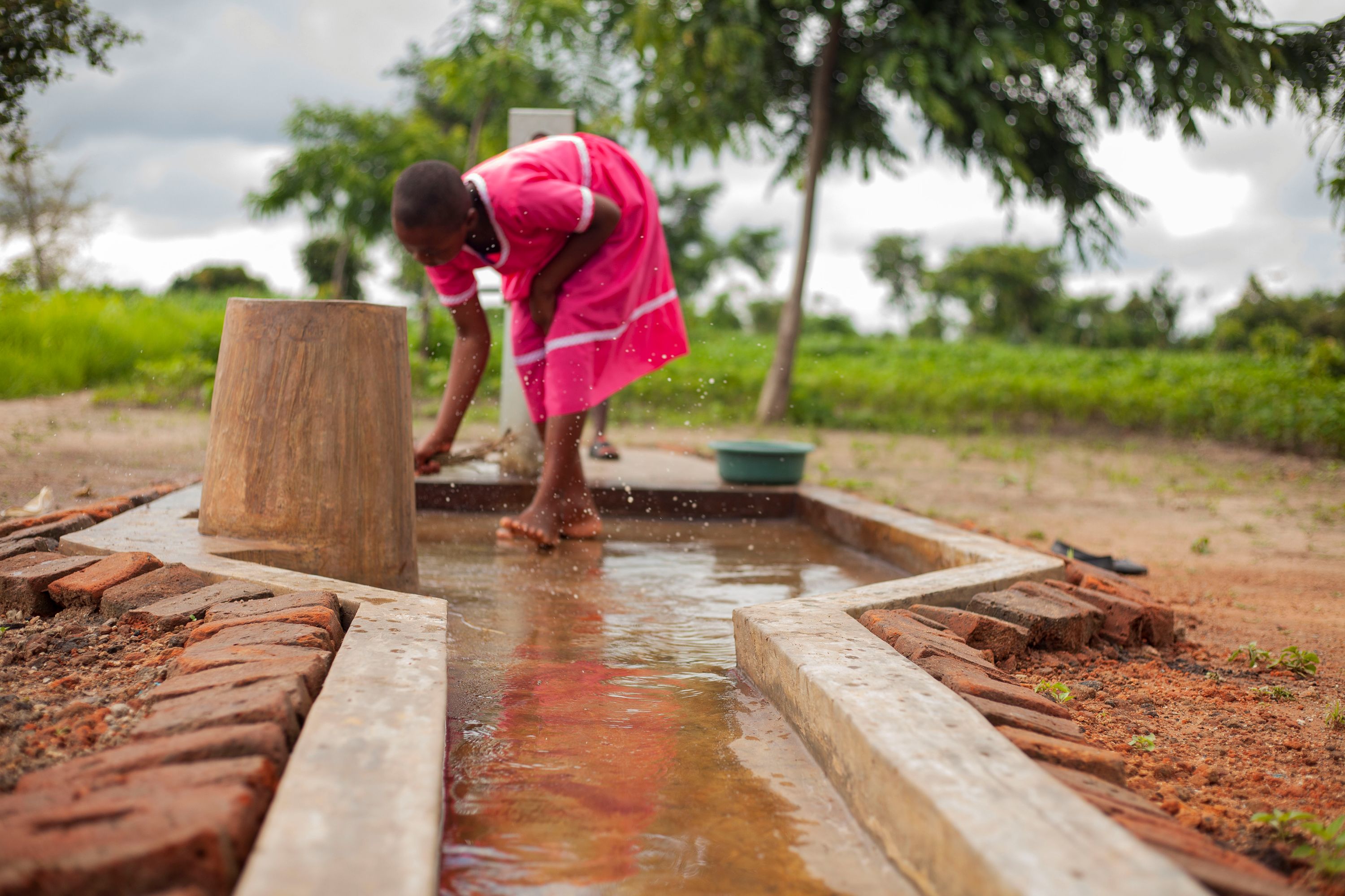 Flora, 11, collects clean water from the village borehole