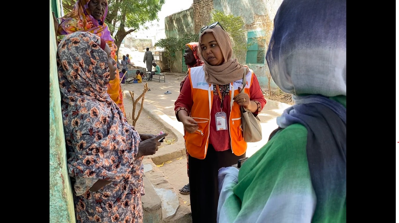 World Vision Sudan female worker with ladies from a community