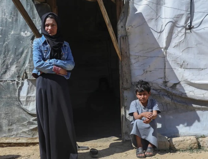 Mother and child outside hut in Lebanon.