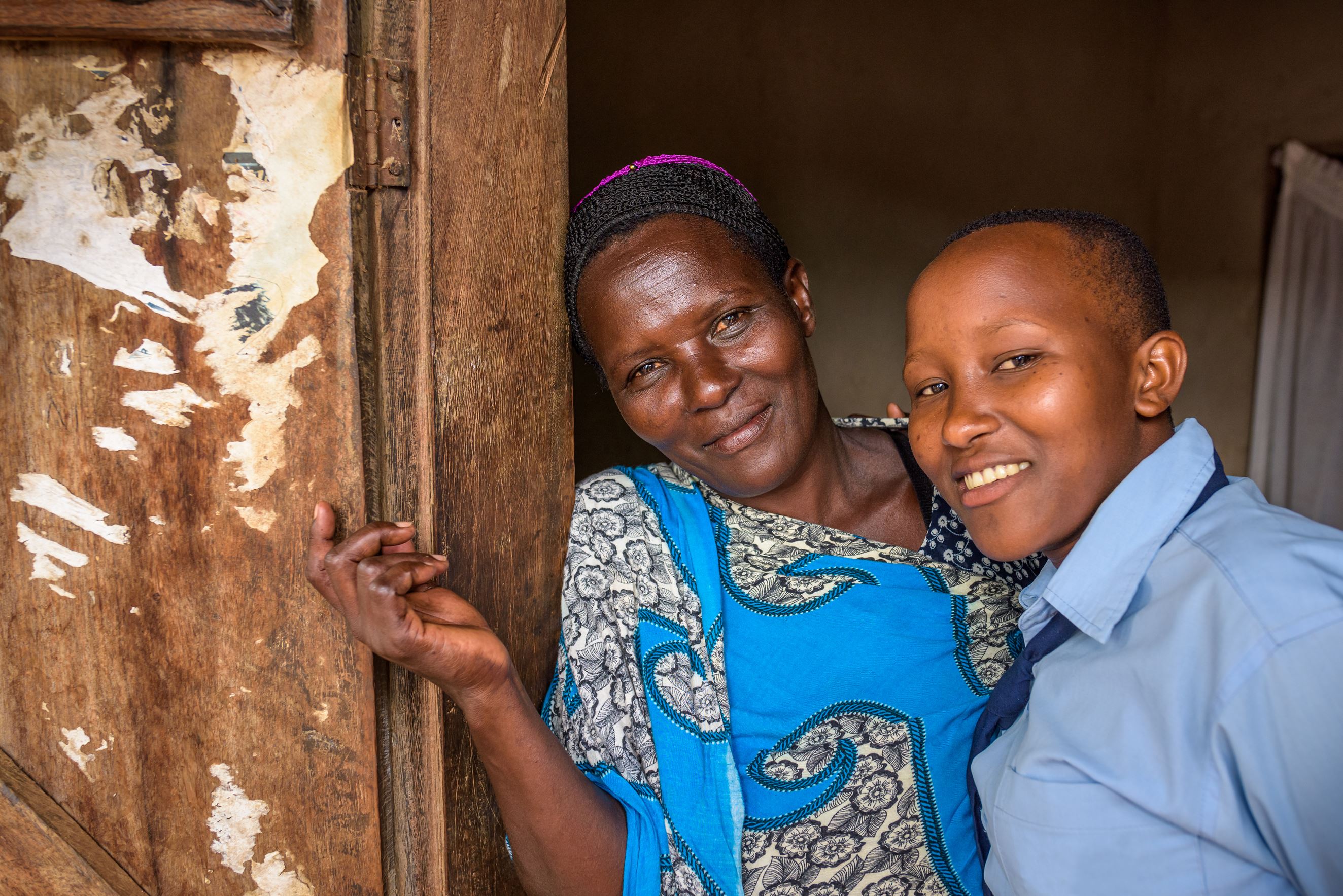 Janet and her mother stand in their doorway