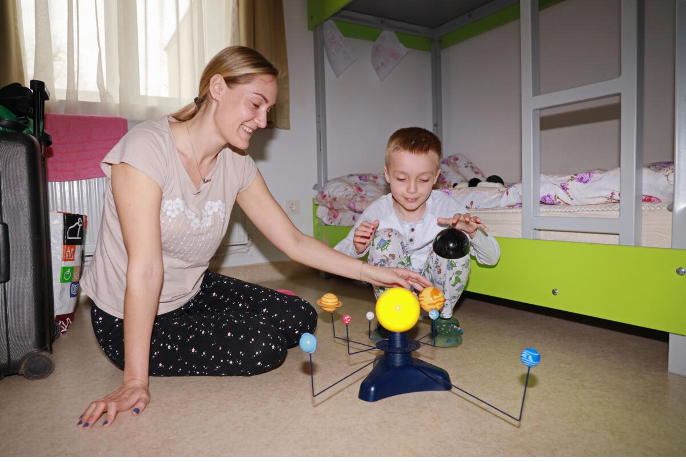 Ukrainian refugee mother and son play with donated toys