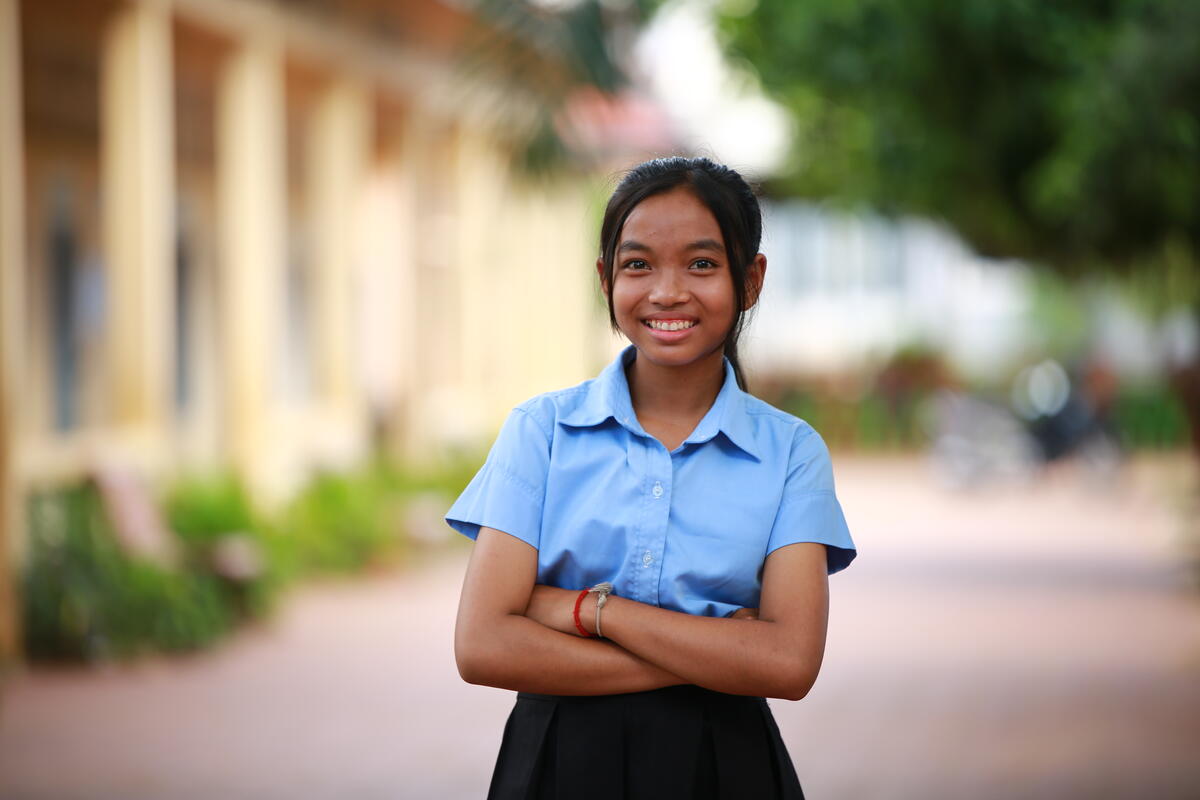 Cambodian girl smiling with her arms folded